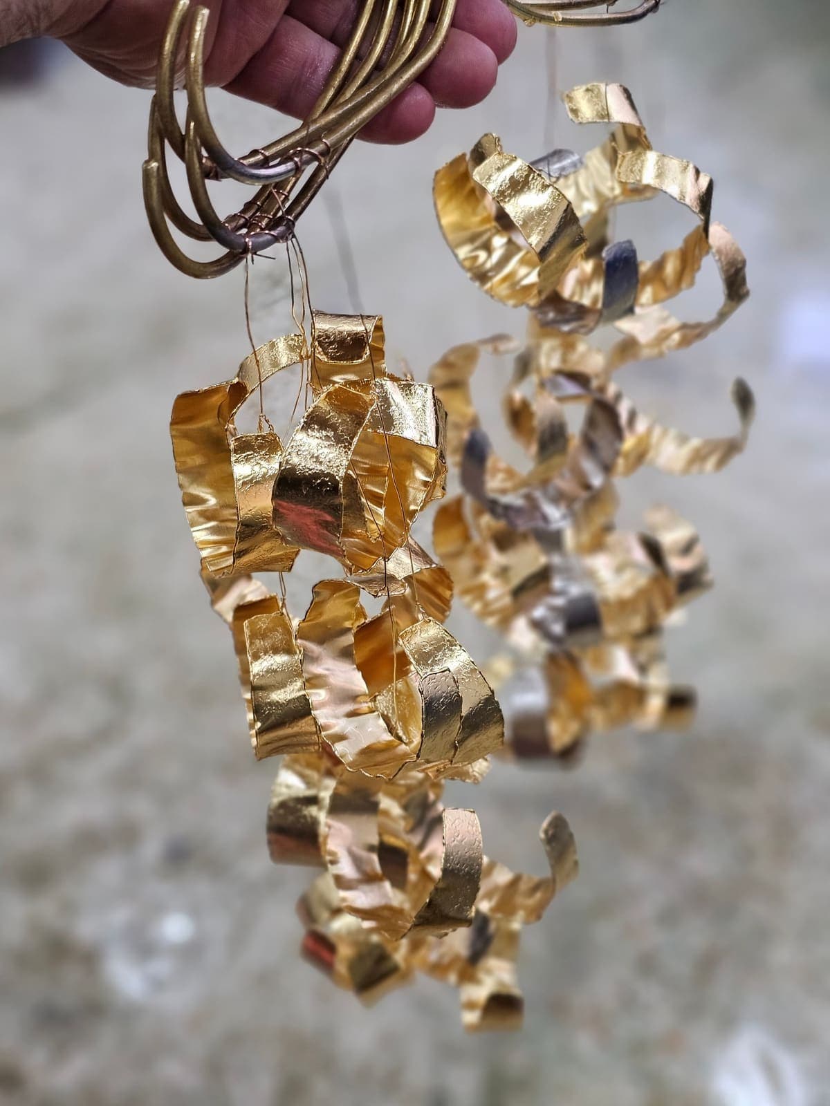Freshly gold-plated pieces hanging from plating wires